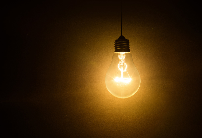 En glödlampa som lyser i ett mörkt rum