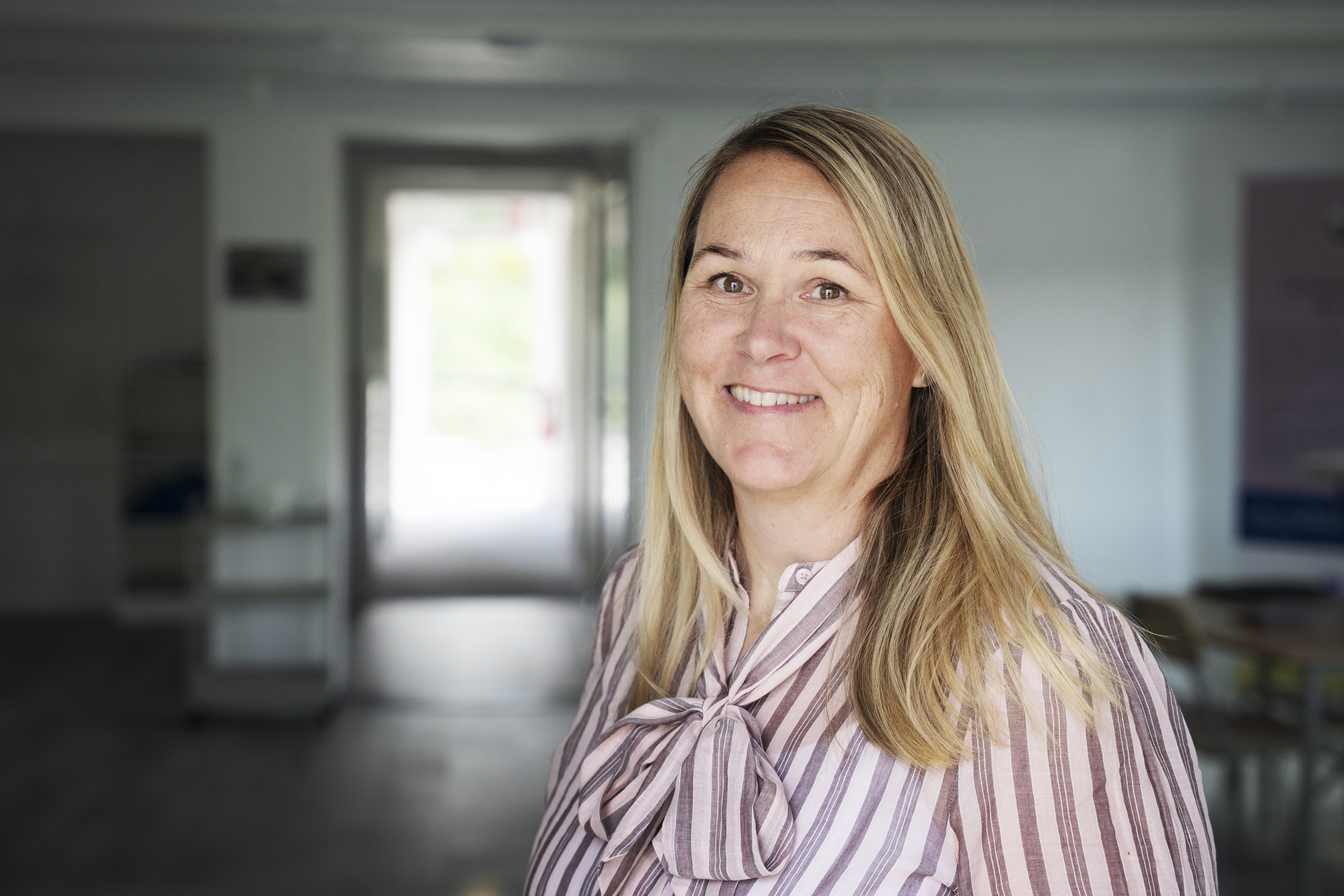 Carin Daal, chef kommunikation och social h&aring;llbarhet Malm&ouml;, portr&auml;ttbild. Blond l&aring;ngt h&aring;r, rosa knutblus, och hon ler in i kameran