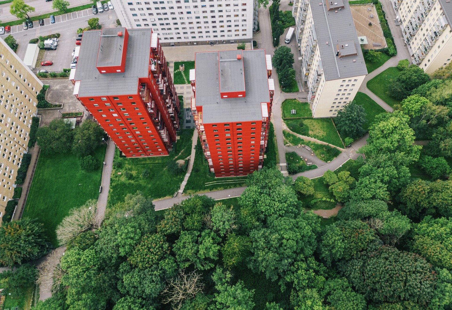 Bild ovanifrån på gröna träd och röda samt vita höghus i Kallebäck i Göteborg