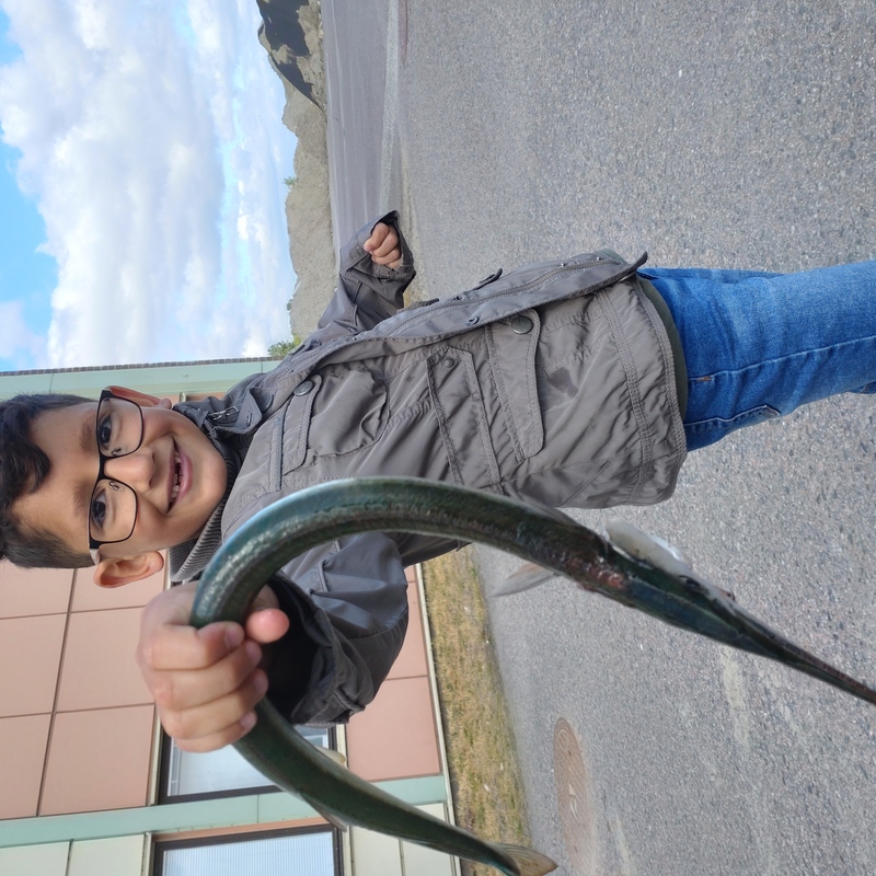 pojke som håller i en lång fisk