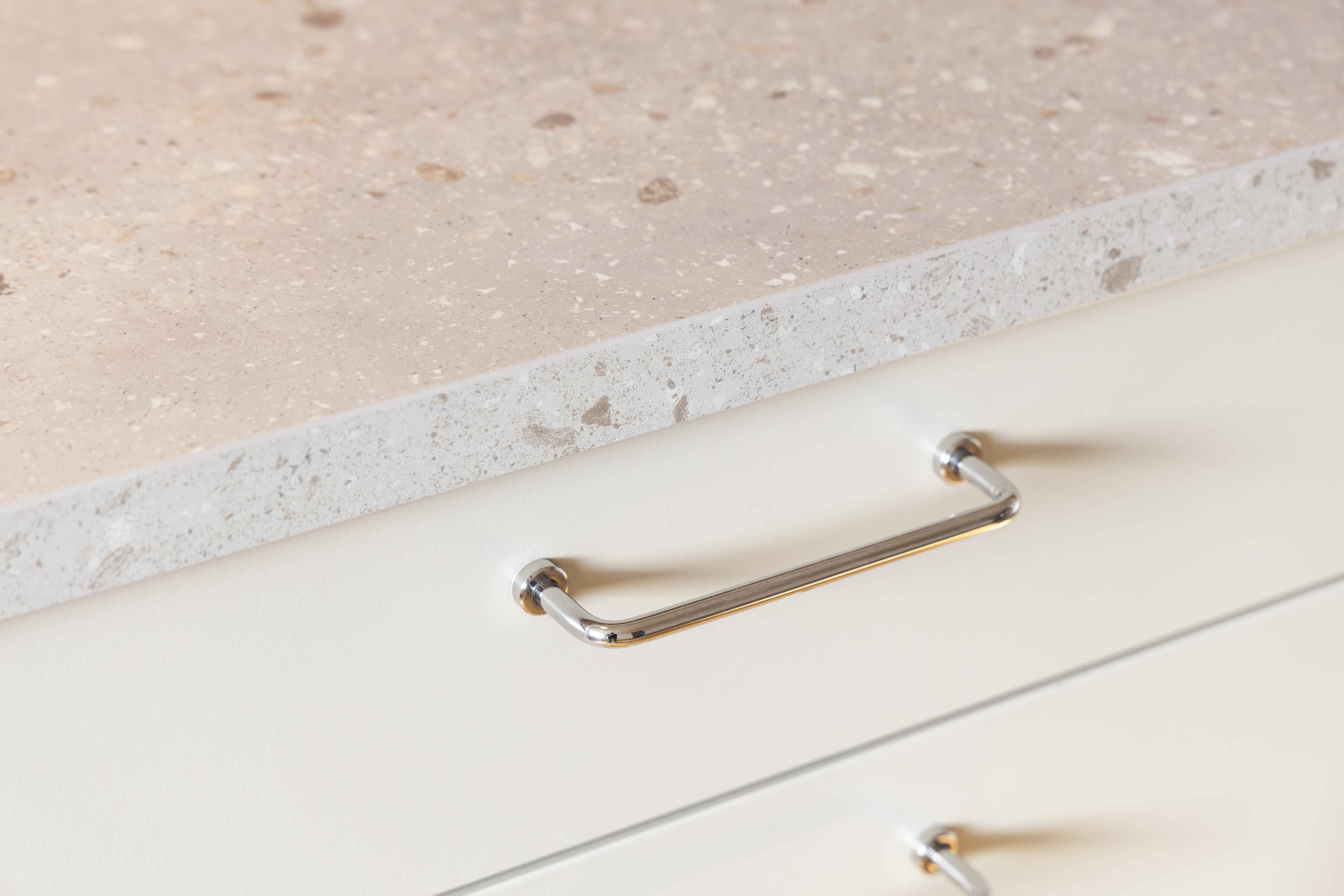 Detaljbild från en plusrenoverad lägenhet med fokus på bänkskiva och handtag