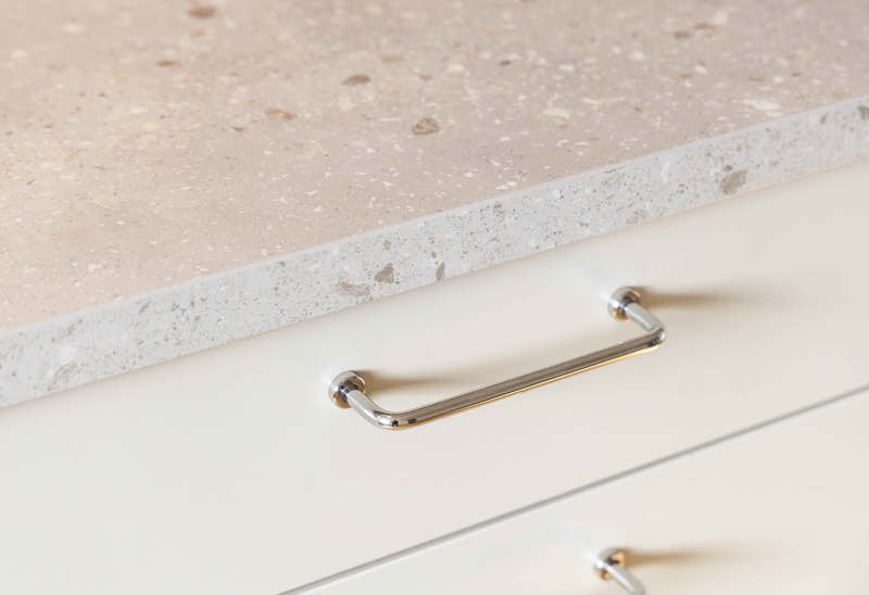 Detaljbild från en plusrenoverad lägenhet med fokus på bänkskiva och handtag