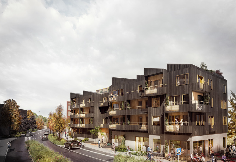 Flerfamiljshus i mörk fasad med stora balkonger, intill en mindre väg med trädplantering