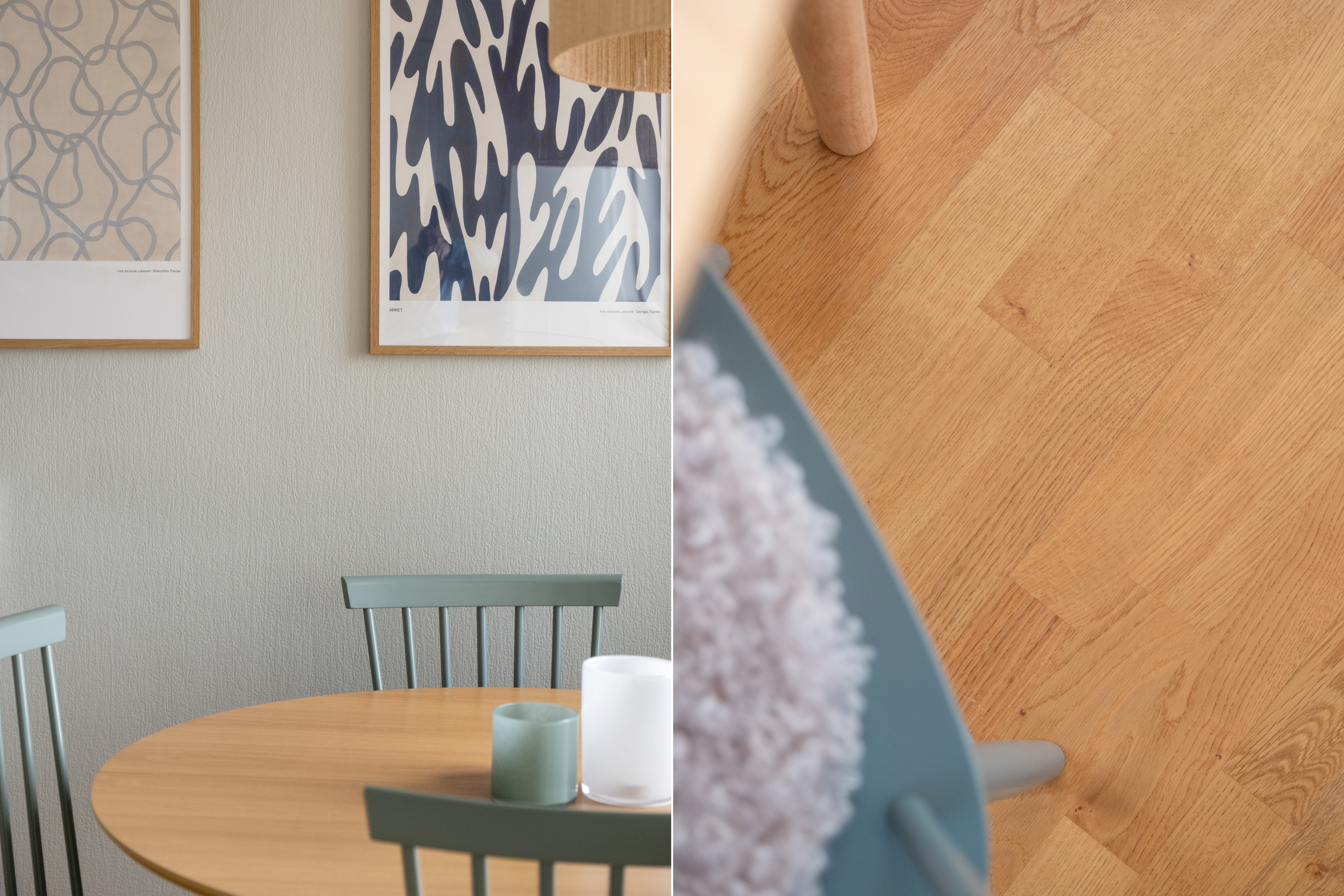 Detaljbild från matplats med runt bord i ljust trä och gröna pinnstolar, där väggen pryds av två abstrakta tavlor i blå toner. Till höger syns en närbild av det varma trägolvet, en stolsben och en sits med mjuk, ljus klädsel.