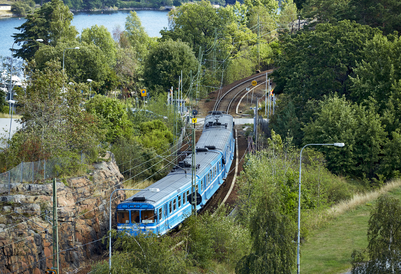 Saltsjöbanan med skog längs spåret, fotad ur ett fågelperspektiv.