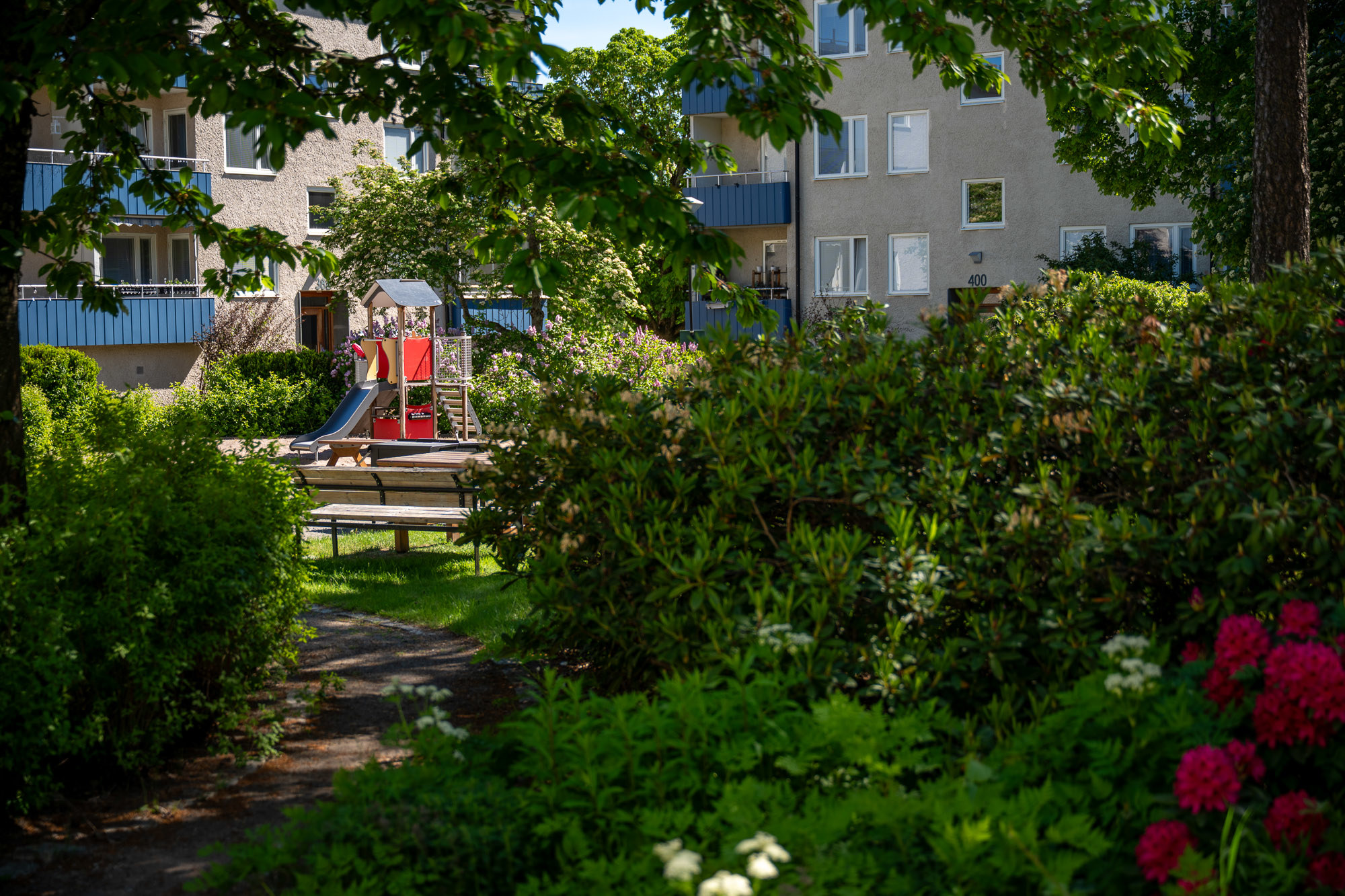 Lekplats och bostadsområde omgiven av grönska