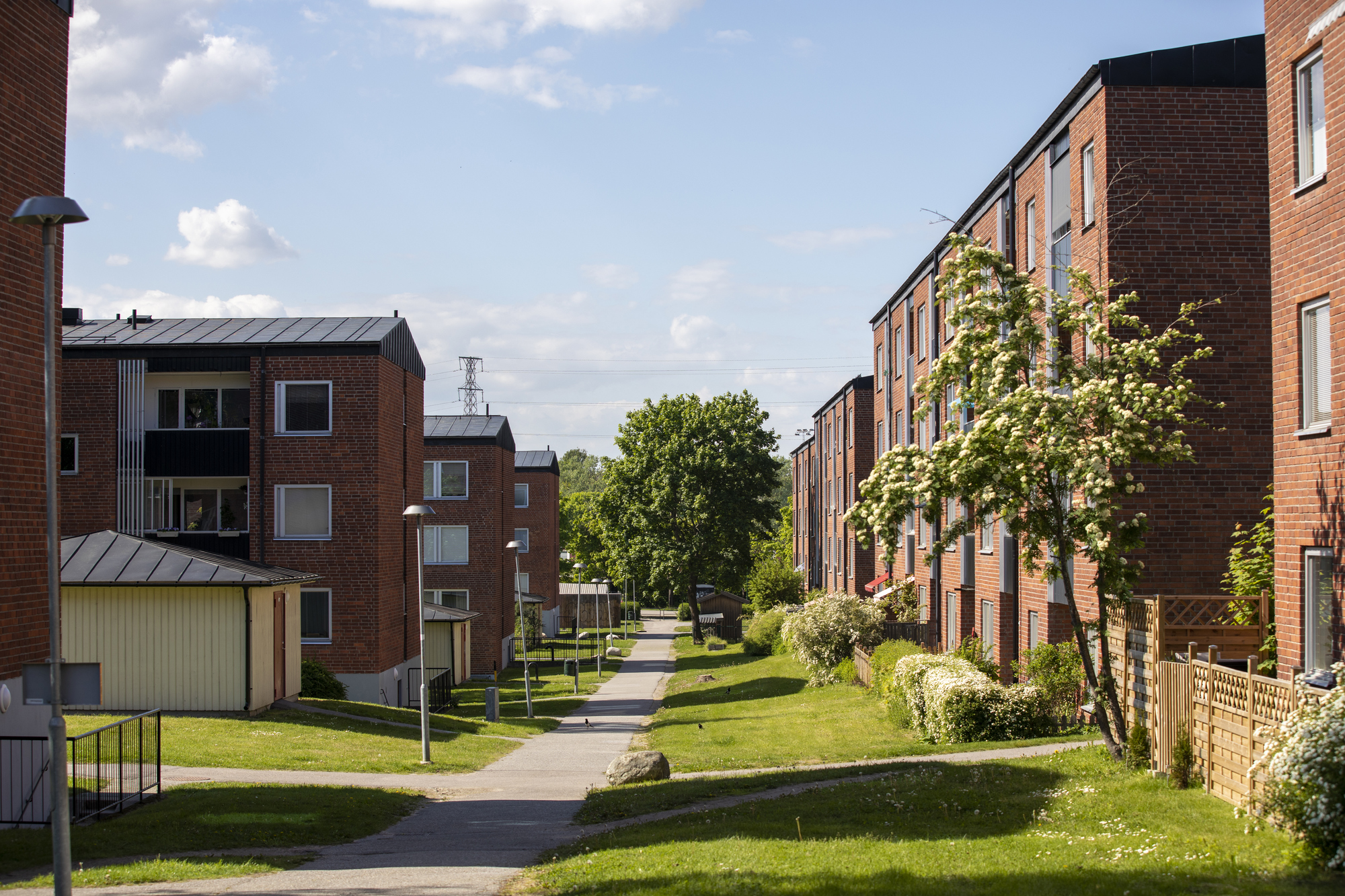 Bostadsområde med tegelhus omringat av gräs. 