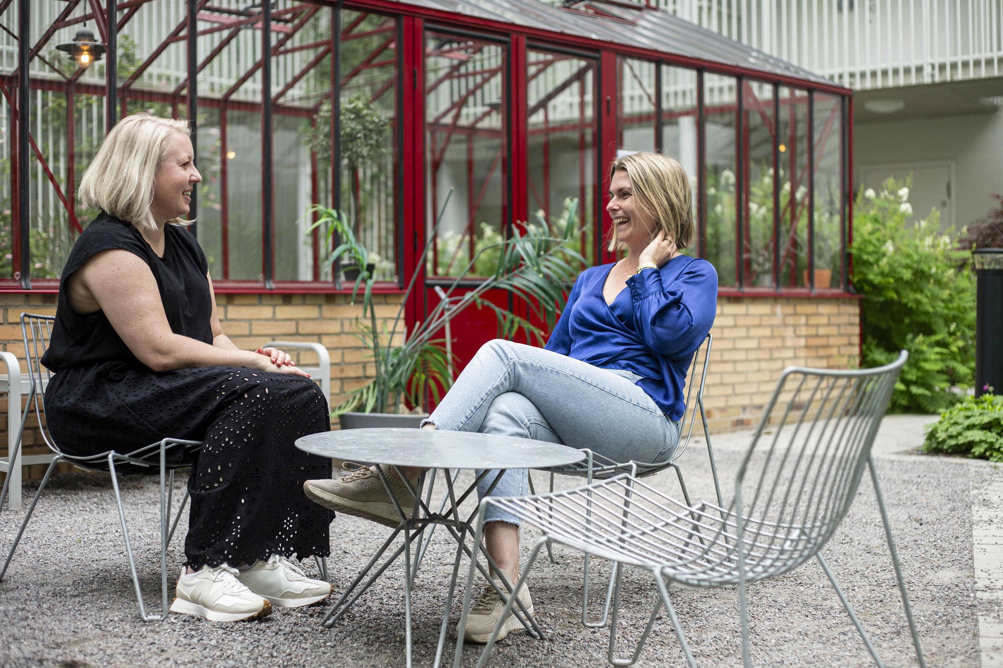 Bild på två väninnor som pratar på innergården