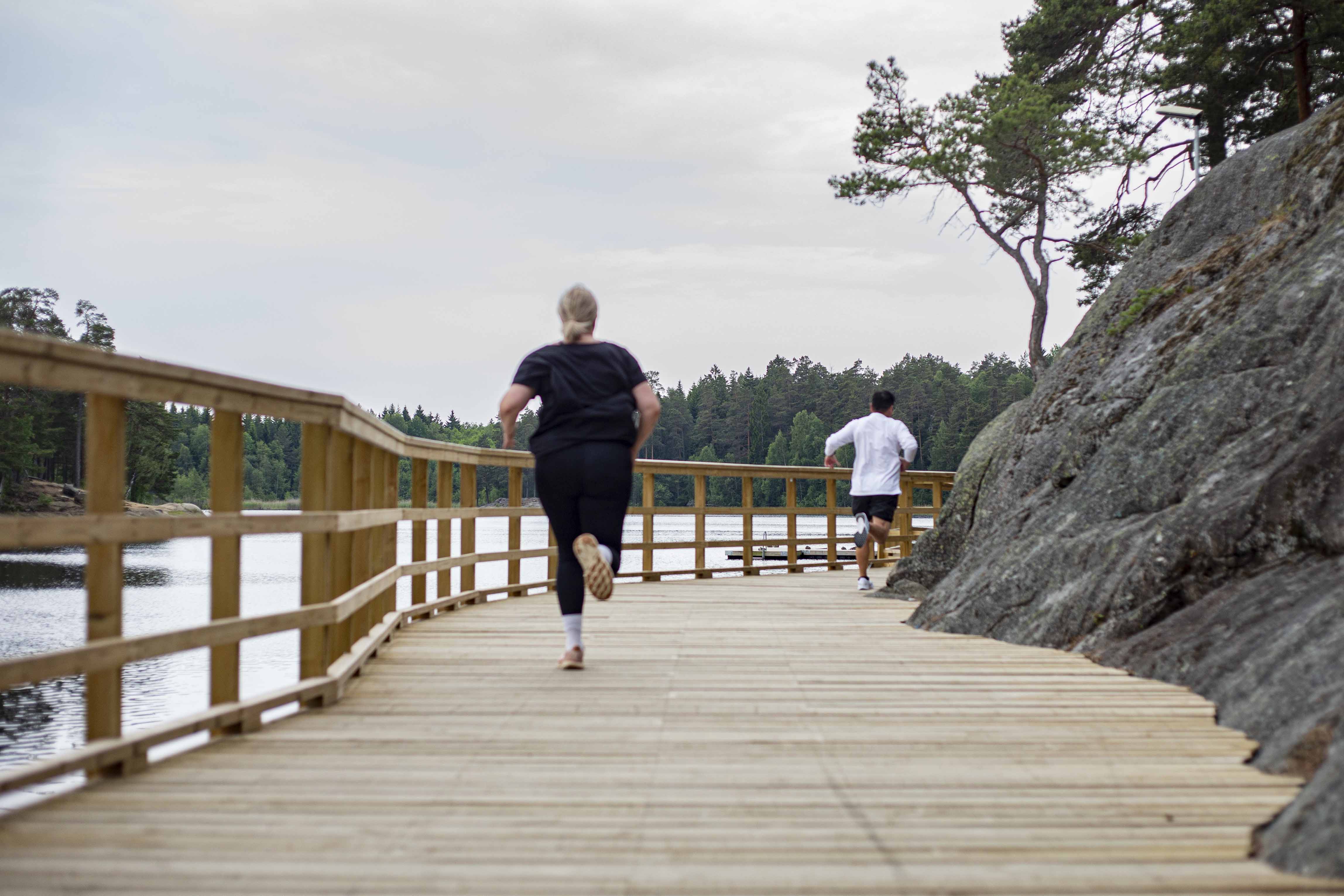 Två personer springer längs med en sjö i Rudan