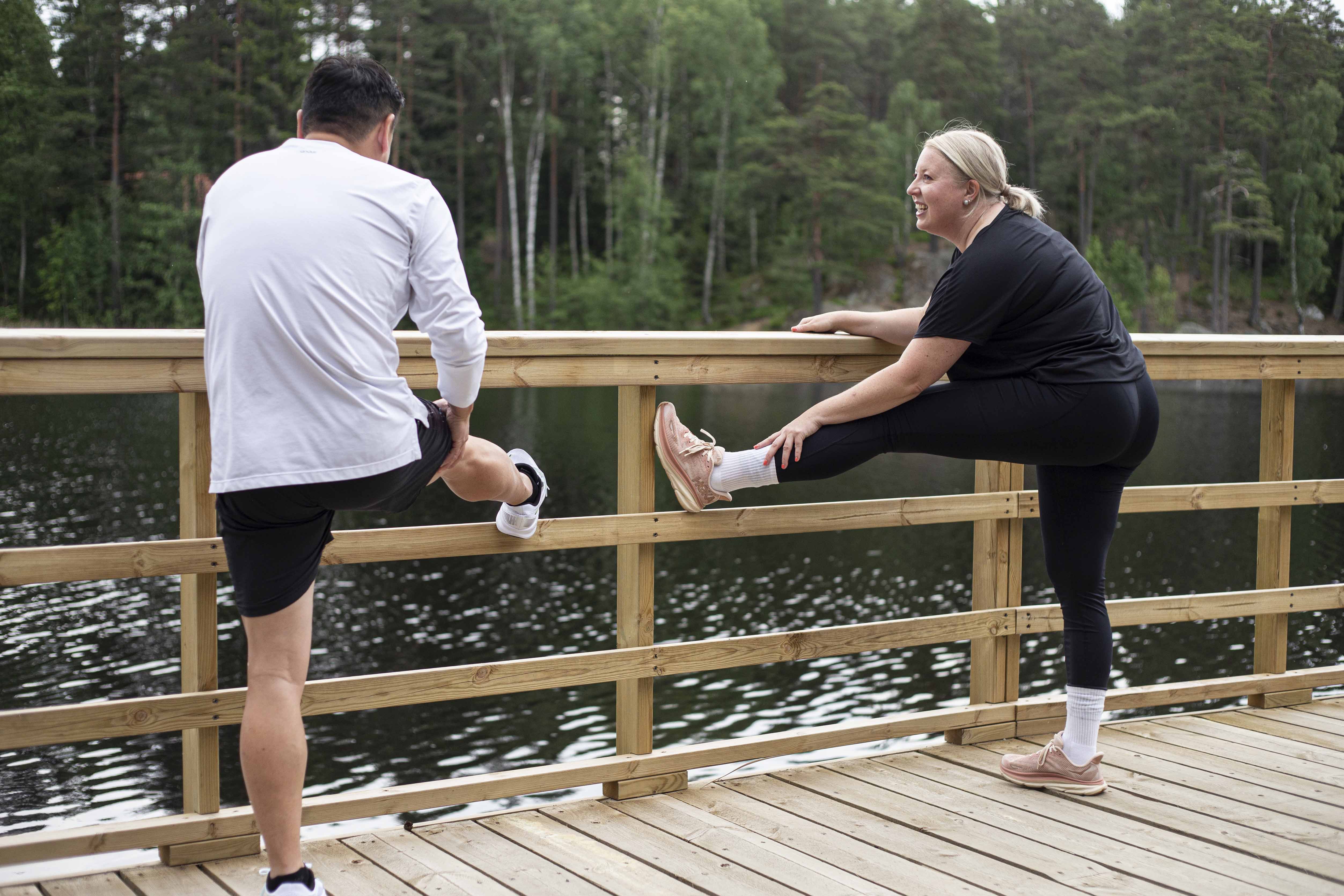 Två personer stretchar efter ett löppass runt i Rudan