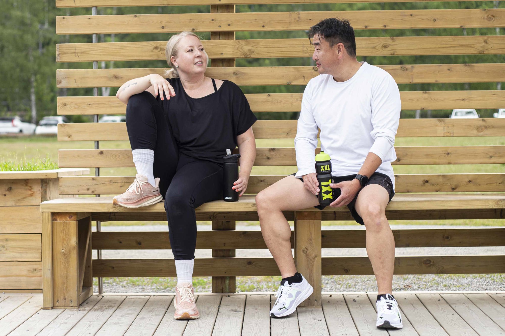 Två personer sitter på en bänk vid Rudan och pustar ut